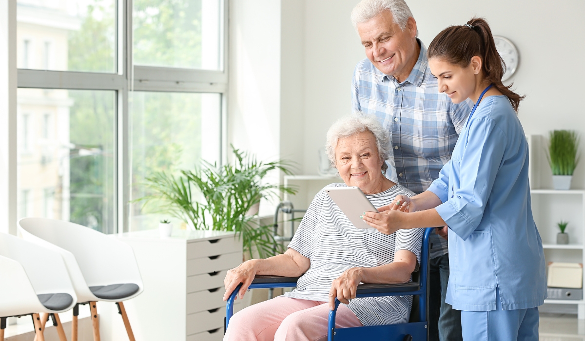 Elderly woman smiling with caregiver in a sunny, peaceful care facility