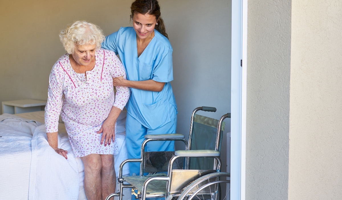Professional caregiver assisting an elderly resident in a comfortable, safe, and welcoming care home environment.