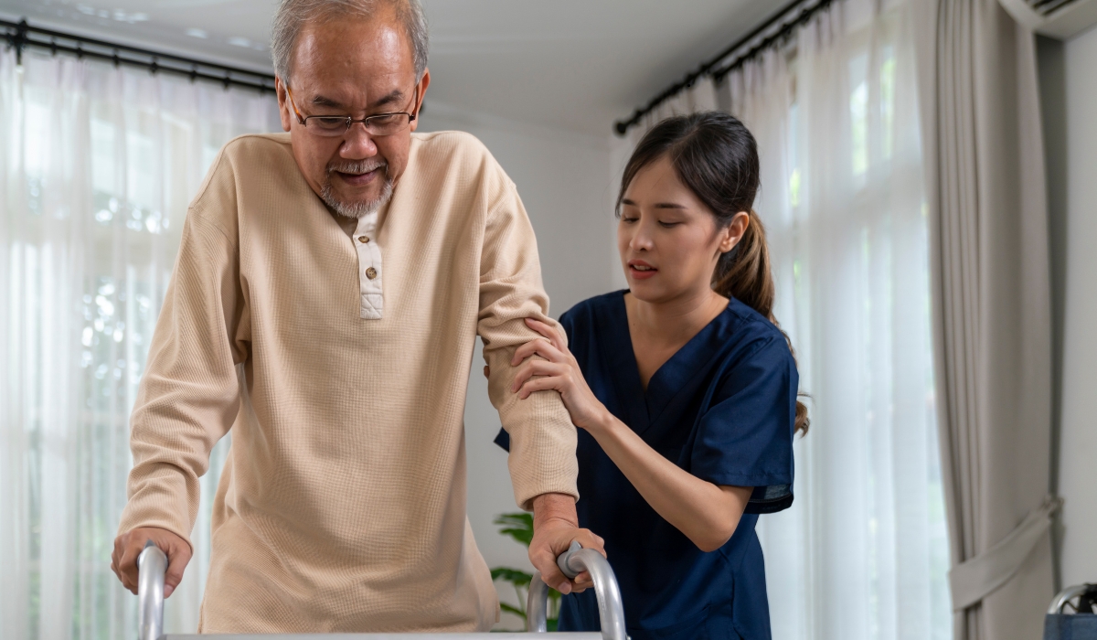 صورة لممرضة تمسك بيد رجل مسن في لحظة إنسانية داخل دار رعاية